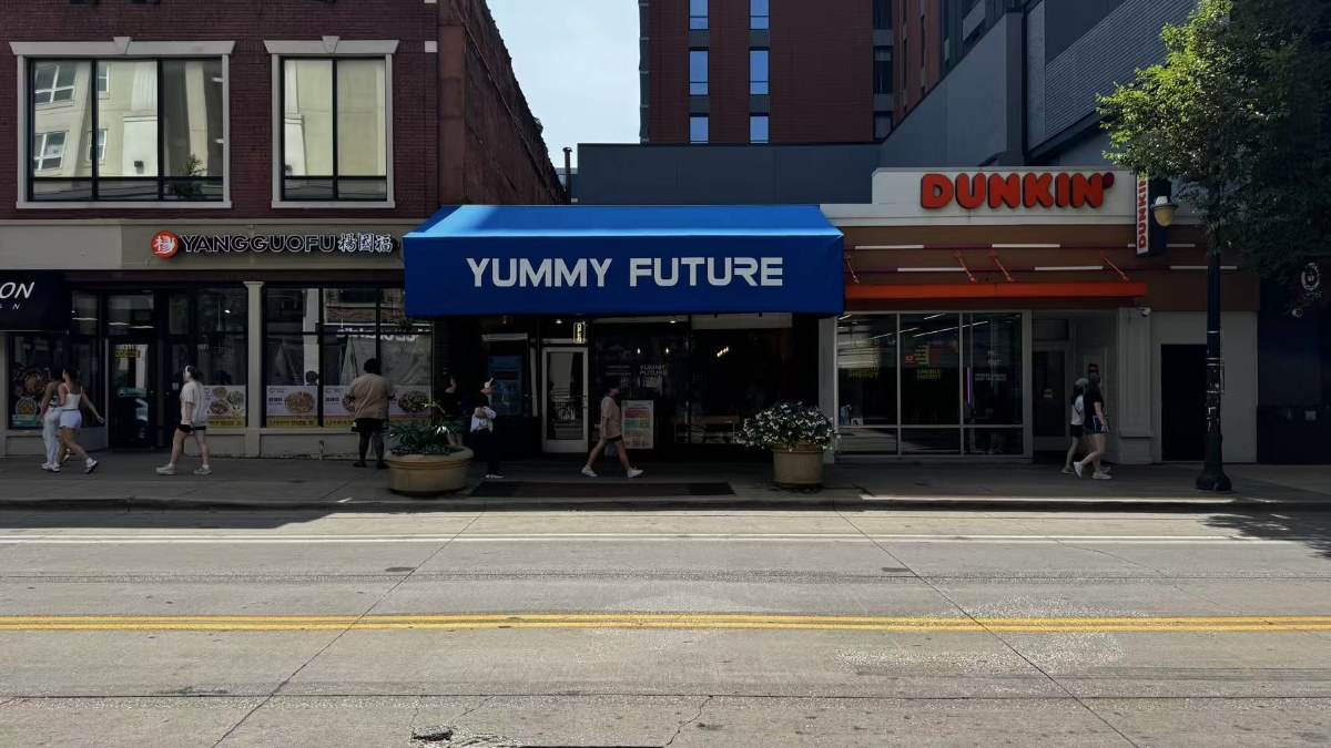 Yummy Future blue awning storefront at 609 East Green Street, Champaign, on a weekday street