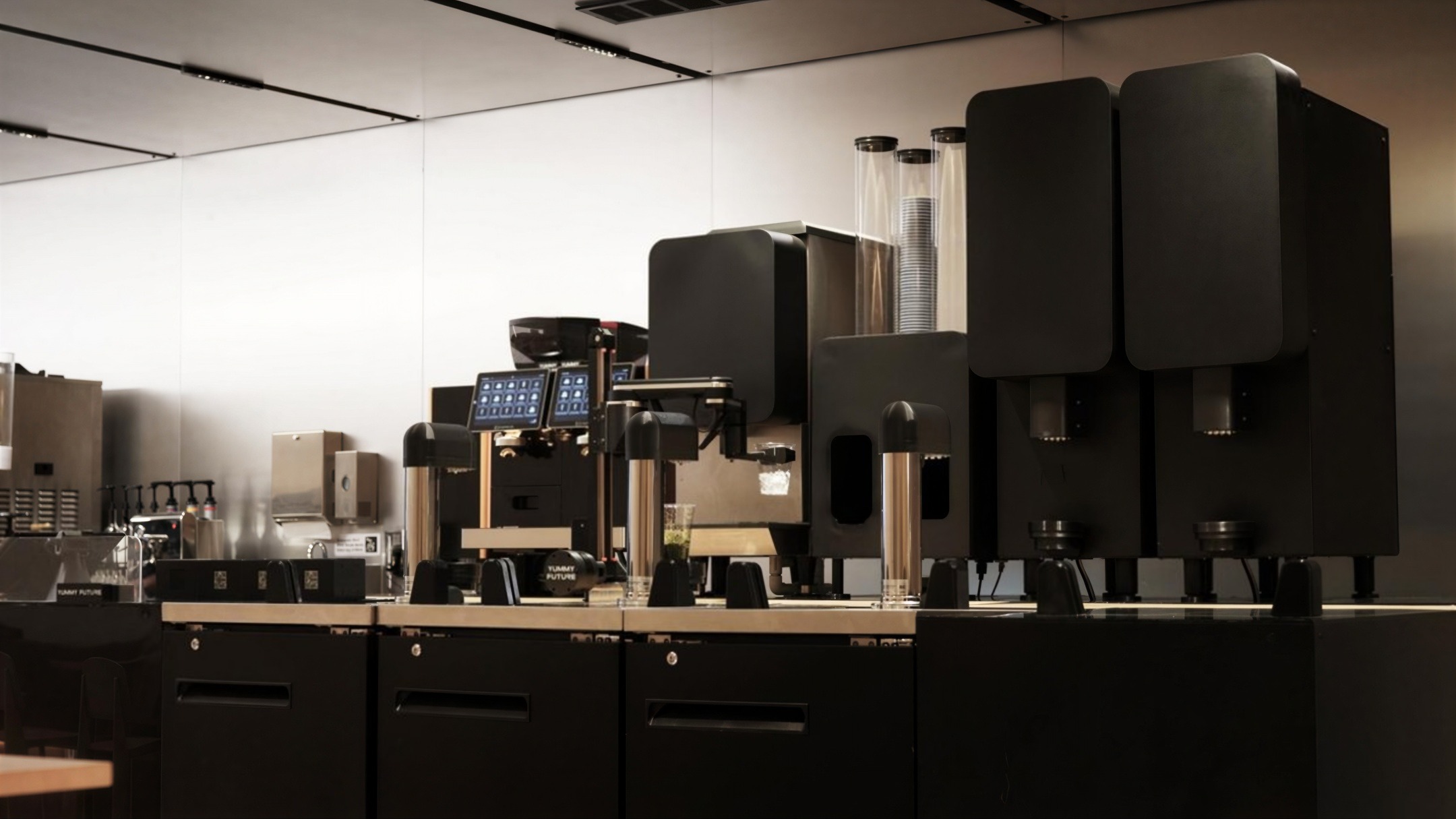 A line of Yummy Future machines along the store bar: dispensing units, cup towers, an espresso module and order screens