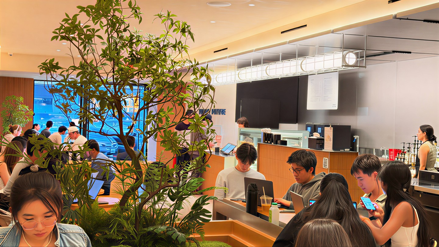 A full room at the Palo Alto store: customers at tables with laptops and drinks