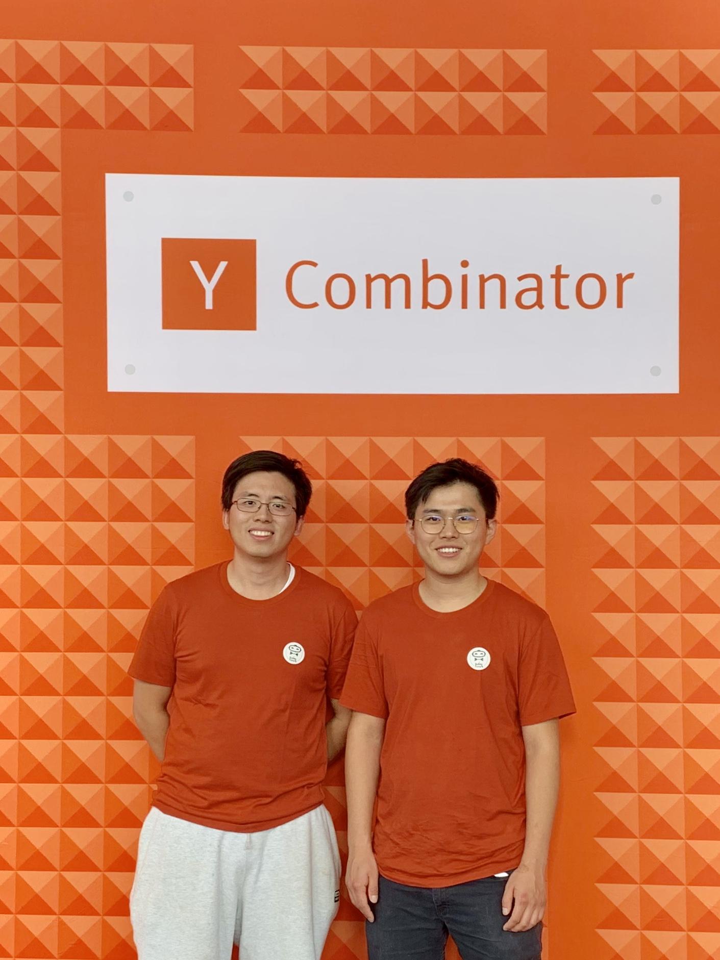 The two co-founders in matching YC tees under the Y Combinator sign, summer 2019